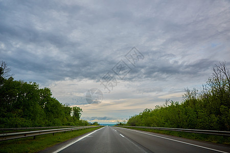 暴风雨前日落时的高速公路交通运动蓝色地平线汽车农村天空速度太阳路线曲线图片
