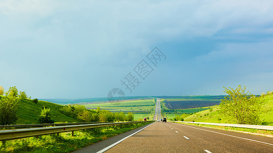 暴风雨前日落时的高速公路交通场景太阳汽车路线蓝色旅行天空农村地平线驾驶图片