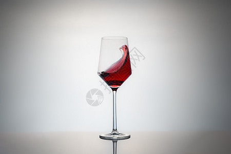 红色葡萄酒杯在灰色背景上被隔绝 底部反射和丰盛的作物图象中产生光滑 (笑声)图片