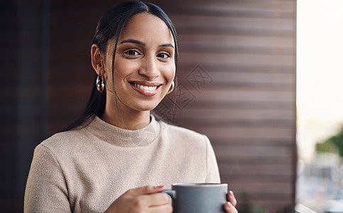 我每上班天都用一杯新鲜的杯子开始 剪裁出一个有吸引力的年轻女商务人士的肖像 在办公室工作时喝着她的咖啡图片