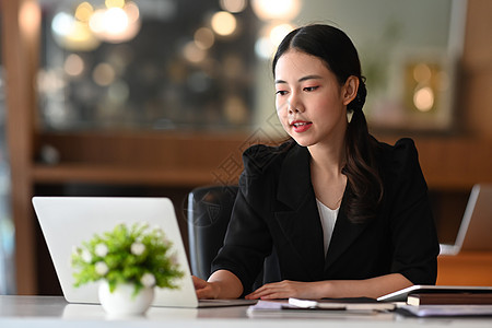 用笔记本电脑工作的 深思熟虑的女商务人士图片