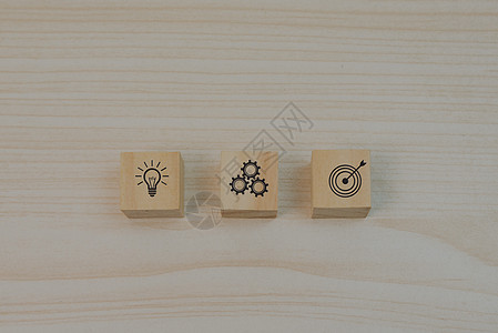 战略目标和投资计划商业营销标志符号装置和灯泡 桌上摆放木块立方体的板块图片