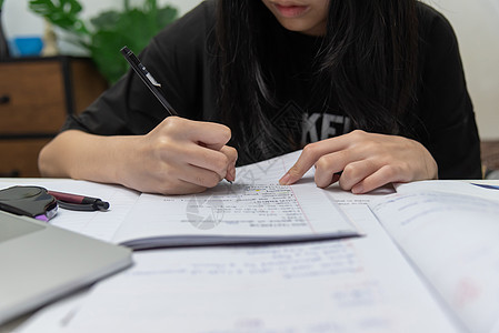 亚裔女学生在书桌上写家庭作业和阅读书学生桌子学习学校教育女孩测试房间童年考试图片