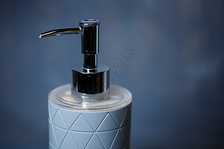 灰色桌上带金属盖盖的灰色肥皂机洗澡淋浴香气家庭卫生间桌子酒店织物液体浴室图片