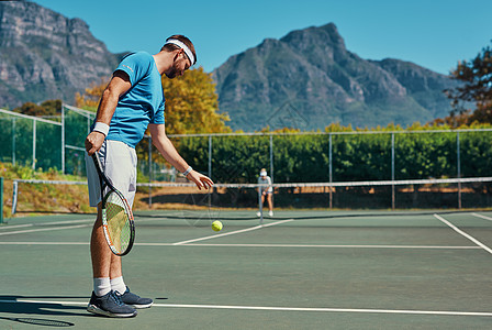 永远也不会好起来的 你只是变得更好 一个年轻的男性网球运动员准备在网球场户外为球服务而拍全镜头图片