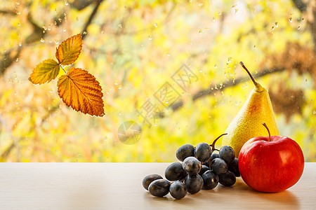 玻璃窗上的梨子 葡萄 苹果和秋黄色叶子 底底水滴模糊图片