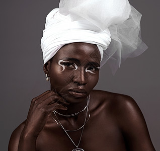 她象征着非洲的美貌 一位有吸引力的年轻女性在灰色背景下穿着传统的非洲服装 拍片时的肖像图片