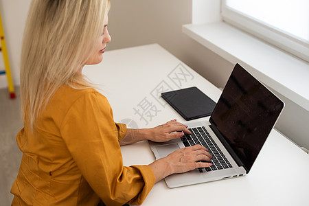 年轻美丽的快乐女人在办公室用笔记本电脑工作时微笑的画面网站教程女性大学设计师职场学习商业黑发桌面图片