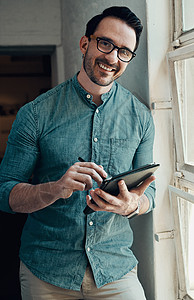 在现代办公室使用数码平板电脑时 一位英俊年轻商务人士微笑的肖像被剪裁成一幅肖像 (掌声)图片
