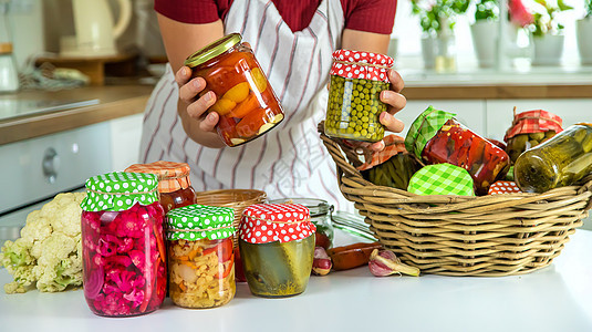 女人罐子在厨房里保存蔬菜 有选择的焦点食物女士发酵消化架子桌子黄瓜装罐女性玻璃图片