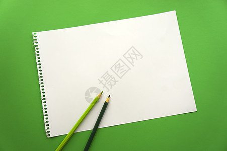 一张空白的纸空间 用于在美丽的绿色背景蓝色铅笔上设计和刻字 从记事本上撕下的穿孔纸斜躺在表面上 方形纸植物小样框架办公室女士叶子图片
