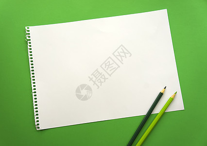 一张空白的纸空间 用于在美丽的绿色背景蓝色铅笔上设计和刻字 从记事本上撕下的穿孔纸斜躺在表面上 方形纸海报热带广告植物女士办公室图片