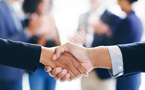 商务人士和女商务人士在现代办公室里握手 他们要用两只手来交易利润丰厚的交易图片