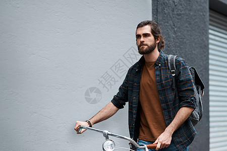 一个英俊的年轻人在户外骑着自行车旅行 校对 Portnoy图片