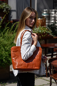 照片中一位美女拿着橙色皮包女人带子旅行办公室工作贮存口袋女性商业魅力图片