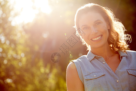 阳光带出最明亮的笑容 一个美丽的年轻女子在公园享受一天的肖像图片