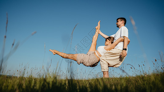 在野外练瑜伽时穿着像做难拍的长相 背景是蓝天 在野外练习Yaga Yoga门外男性夫妻女士日落闲暇福利专注女性成人活力图片