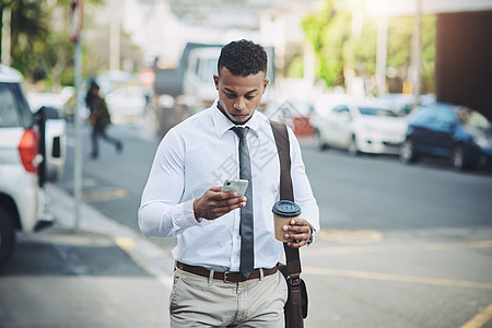 对于移动中的人来说 连通性就是一切 一个英俊的年轻商务人士在城市里使用手机图片