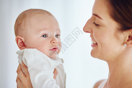 一位快乐的年轻母亲在家里抱着她可爱的男婴 在享受为人父母的同时建立亲密关系 单亲父母嬉戏而深情 与刚出生的小孩一起度过宝贵的时光图片