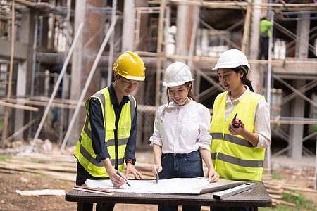 年轻的亚洲检查员和建筑师与总工程师讨论建设项目经理工人领班团队工程师头盔标志安全帽商业工作图片
