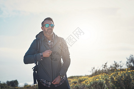 一个中年男子在山上徒步旅行 爬到山里图片