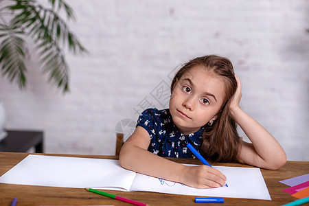 鼓动坐在桌边的小女孩 用蜡笔画画画或者在家工作描绘艺术家草图铅笔女孩蜡笔学习画家工作室幼儿园图片