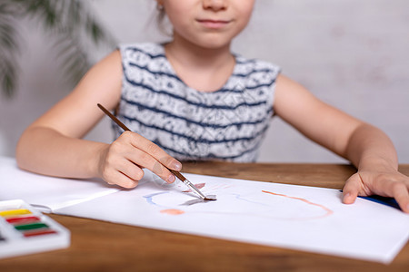 鼓动坐在桌边的小女孩画彩画专辑草图快乐童年蜡笔创造力油漆女孩描绘桌子图片