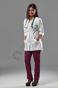 美丽的年轻医生 穿着医疗长袍和听诊器黑发女孩治疗职业裤子医院高跟鞋临床冒充外科图片