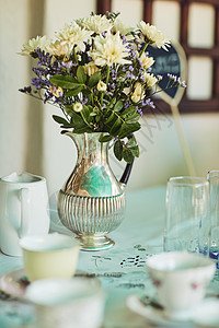 没有花瓶的优雅派对算什么 一个装满鲜花的金属花瓶放在里面的茶话会的桌子上图片