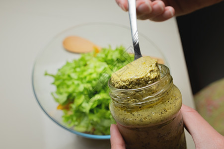 美味的新鲜沙拉菜食用新鲜沙拉 在玻璃碗里加辣椒酱 背景浅薄 从上方查看饮食草药美食盘子勺子叶子烹饪食物女性蔬菜图片