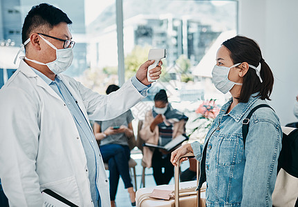 Covid 与一名医生一起旅行 在机场为一名戴口罩的妇女测量体温 以确保大流行期间的安全 医疗保健专业人员按照旅行协议使用红外线图片