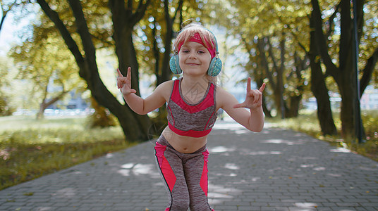 体育跑跑跑女学生训练练习 在耳机上听音乐 用照相机跳舞 玩得开心有氧运动运动员自由行动快乐音乐活动跑步慢跑者运动装图片