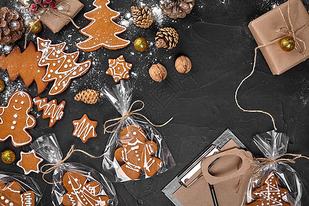 黑色桌子背景上用玻璃纸包装的圣诞树形状的圣诞姜饼曲奇饼 圣诞礼物的概念假期糕点蛋糕礼物饼干雪花食物创造力庆典生日图片