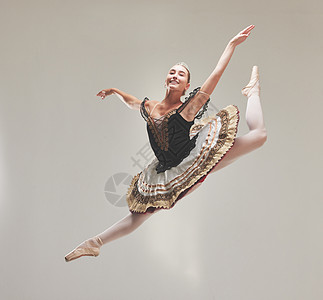优雅的芭蕾舞演员以复古风格跳舞 在工作室里跳跃和表演 一位技术娴熟 才华横溢 年轻的芭蕾舞演员在空中高高跃起享受表演的肖像图片