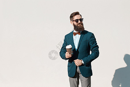穿着外套 衬衫和领结的留胡子的时髦男子夹克绅士成人口袋男性街道人士男人伙计城市图片