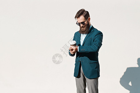 在阳光明媚的日子 穿着夹克 衬衫和领结的留胡子的时髦男子图片