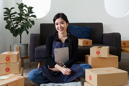 幸福的亚洲中小企业女企业主在家庭办公室工作 网上购物概念图片