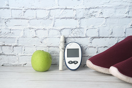 桌上的糖尿病测量工具 鞋和苹果疾病病人治疗葡萄糖电子药片粉色绿色控制测试图片