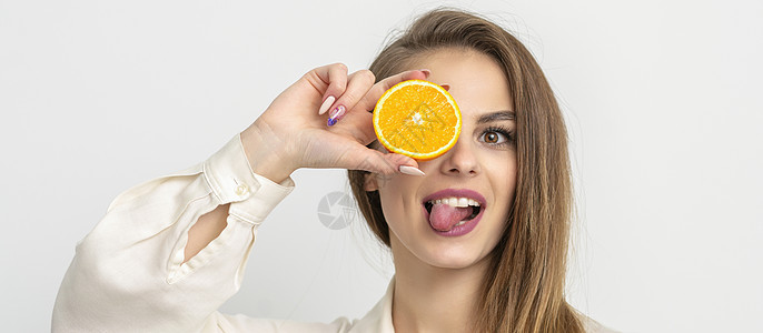 妇女用橙色遮眼食物橙子舌头女孩展示牙齿隐藏黑发橘味横幅图片