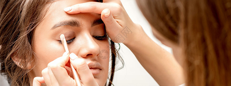 化妆师应用眼影横幅产品刷子沙龙魅力眼皮工作室黑发女孩睫毛图片