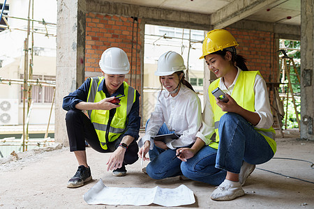 结构工程师和建筑师讨论并使用户外建筑工地的蓝图进行工程研究与工作以及工厂经理建筑学财产构造商业安全合作控制男人图片