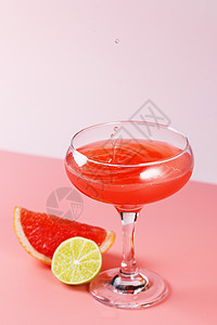 新鲜的葡萄柚汁滴落在粉红色背景的玻璃杯中 粉红色背景中有葡萄柚片和酸橙 复制空间异国营养水果美食早餐水壶情调叶子柚子玻璃图片