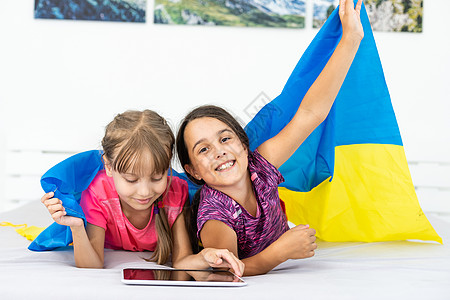 两个小女孩 举着乌克林的旗子女孩孩子们孩子花圈童年艺术油漆幼儿旗帜合作图片