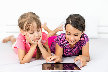 利用平板电脑作为艺术板的小女孩     一起绘画女孩朋友冲浪学习触摸屏技术童年孩子们地面互联网图片