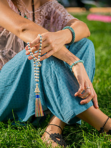 女人 点燃的手特写 数着 Malas 在咒语冥想期间用来计数的木珠串 佛教 夏天坐在公园里的女孩珠子沉思祷告女士专注念珠上帝瑜伽图片