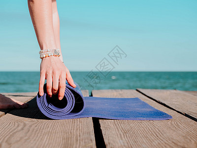 年轻漂亮的运动女青年准备在水边海滩上做瑜伽 女孩覆盖紫色垫子 健康概念日落女士精神训练沉思生活压力冥想姿势天空图片