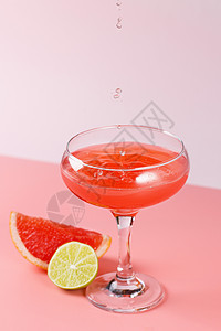 新鲜的葡萄柚汁滴落在粉红色背景的玻璃杯中 粉红色背景中有葡萄柚片和酸橙 复制空间饮料玻璃食物情调茶点水壶热带柳条果汁水果图片