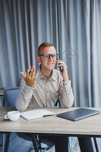 成功人士在办公桌上上网时用智能手机聊天和浏览上网本电脑电话职场自由职业者商务互联网工作技术工人企业家图片