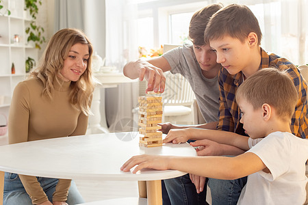 家庭 在家里充满热情地玩一个木制矩形区块组成的棋盘游戏图片