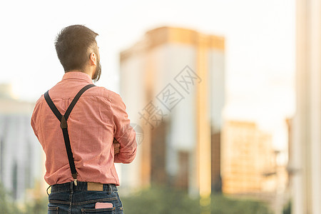 一个男人的背面 看着城市风景与摩天大楼图片